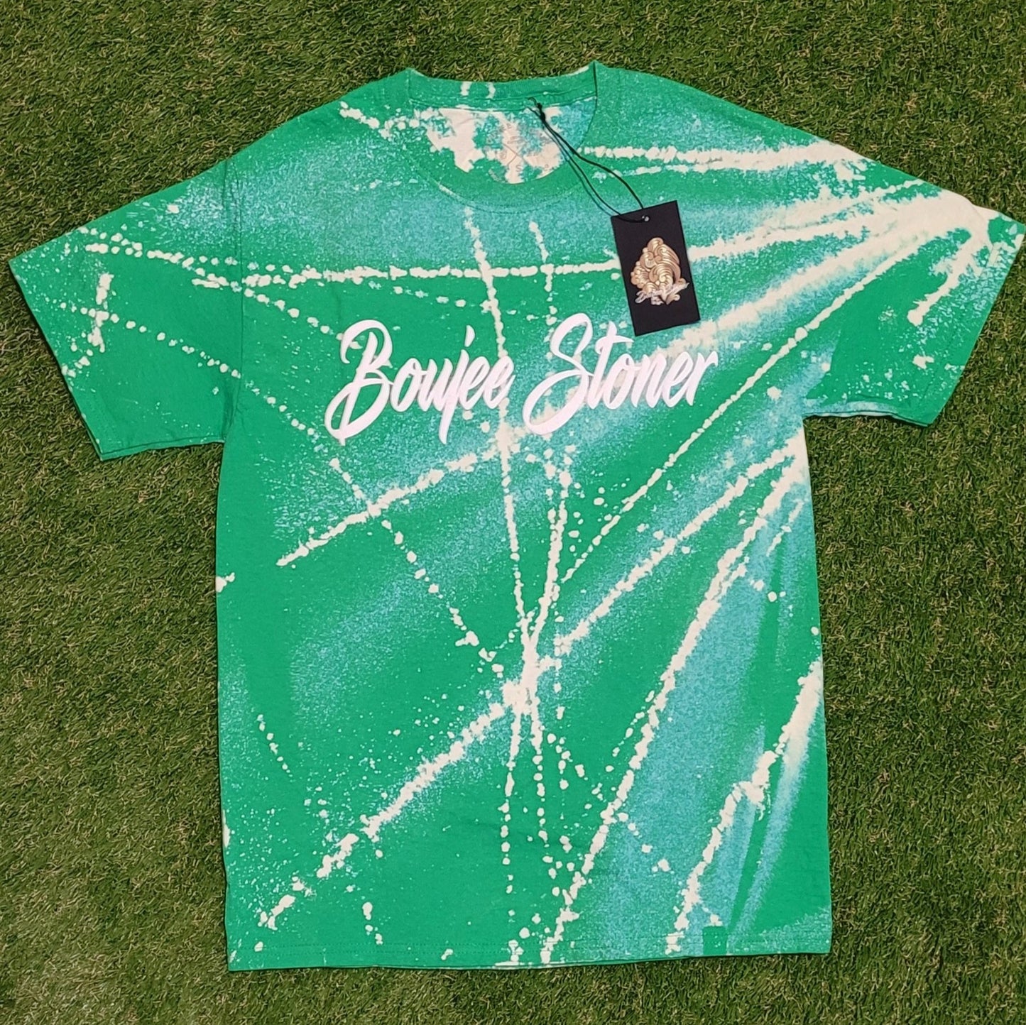 Close-up of a vibrant green Boujee Stoner Bleached Tee with a unique white splatter design.