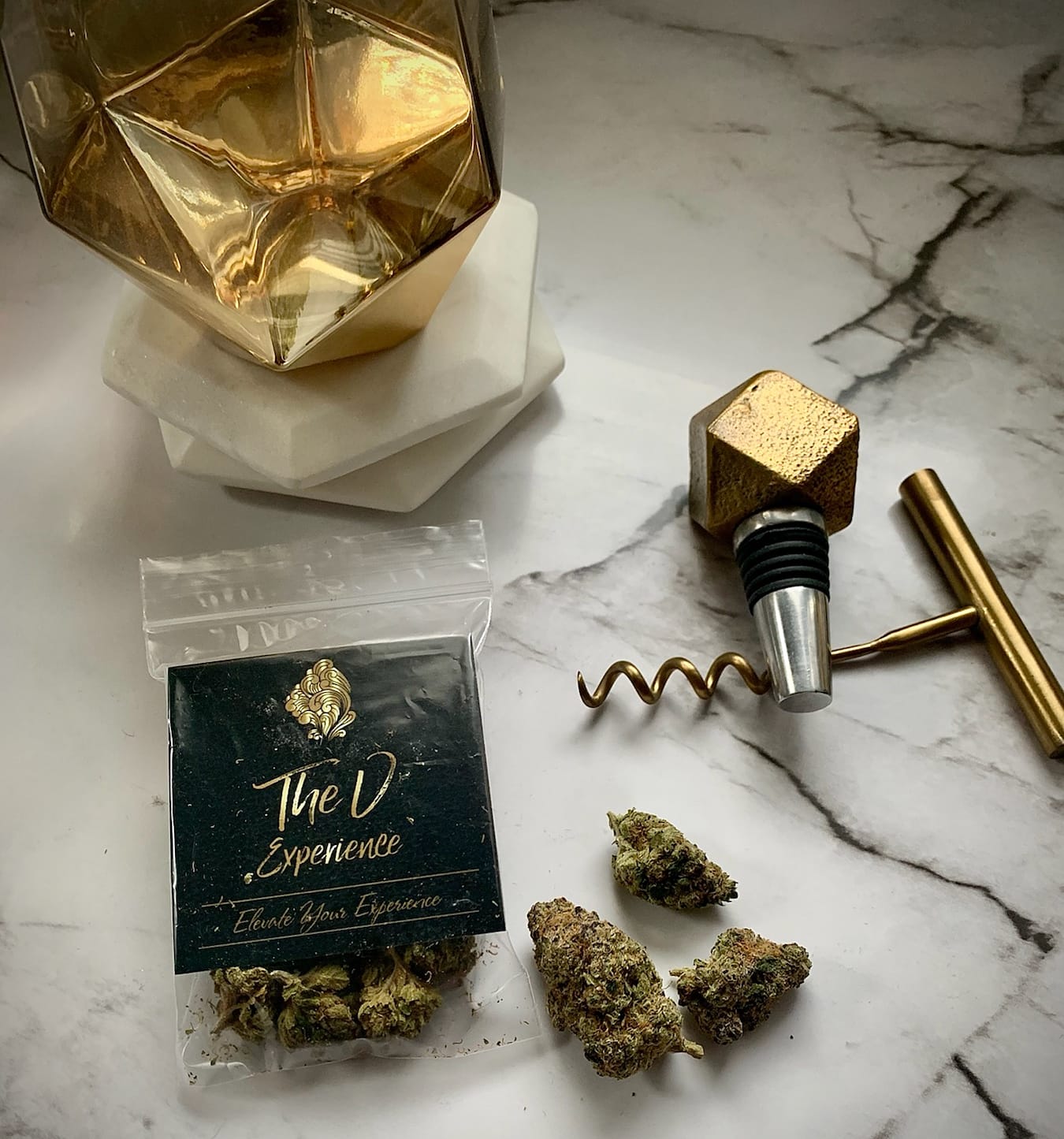 Black Boujee Stoner gift card with gold logo, leaning against a gold geometric wine stopper on a marble surface.