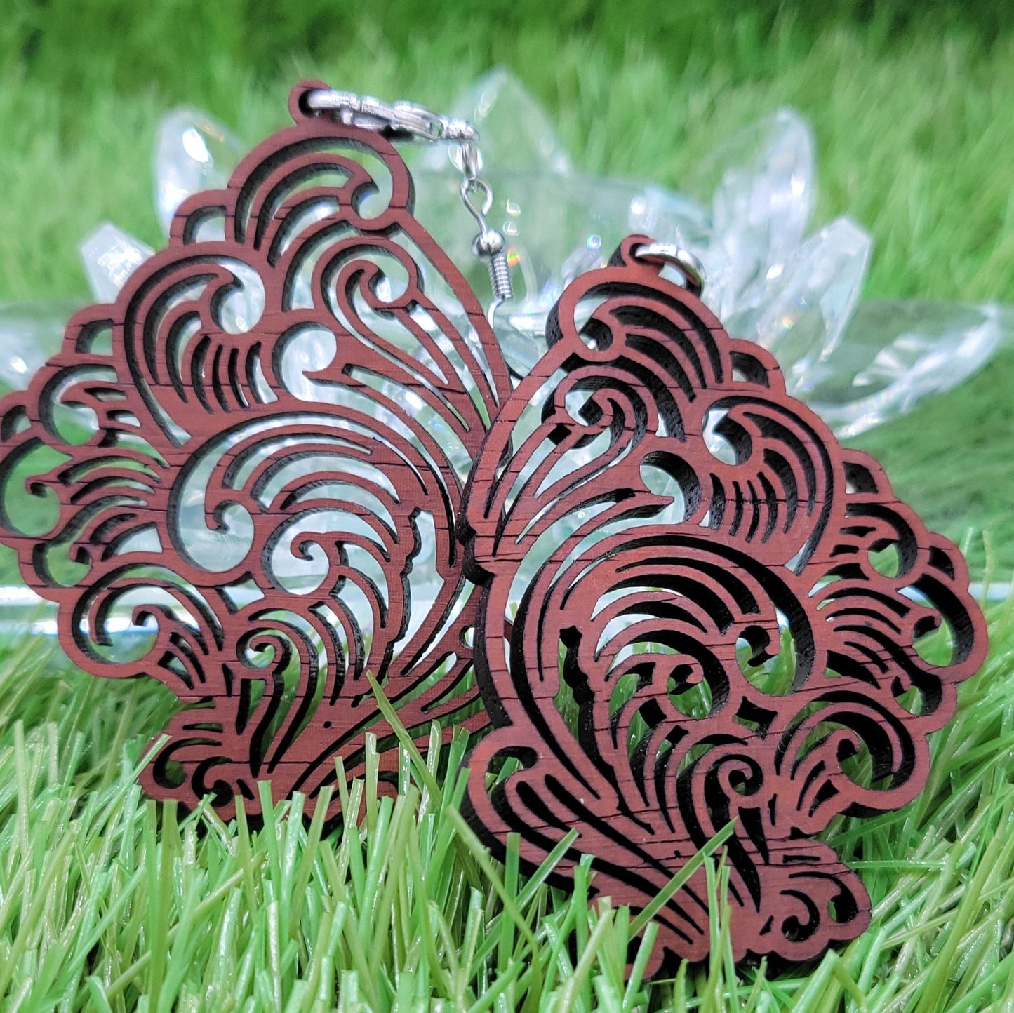 A pair of richly colored Boujee Stoner Vapor Earrings made from padauk wood, highlighting their intricate design and reddish-brown hue.